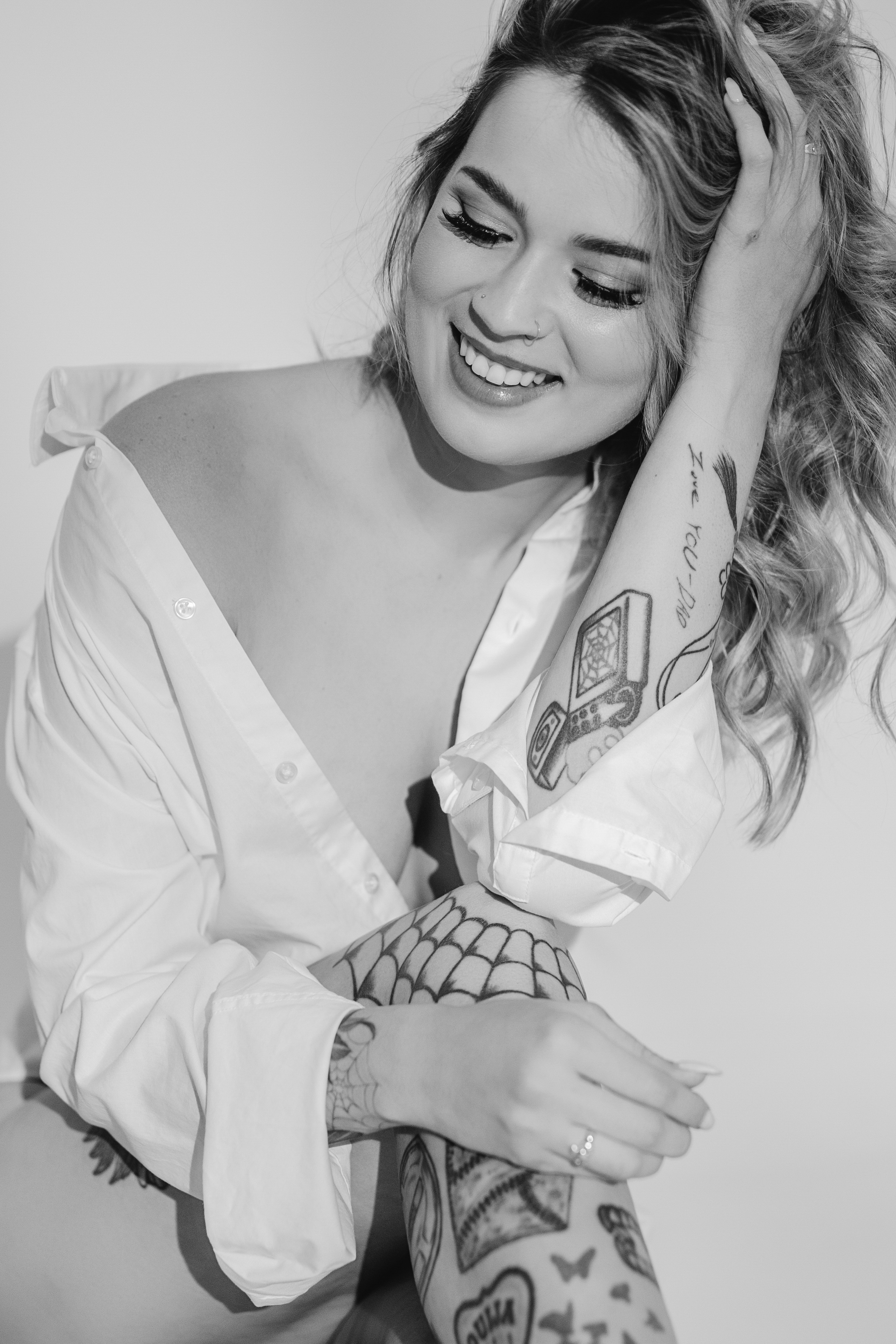 Smiling woman in a white shirt in a black-and-white Boise boudoir portrait