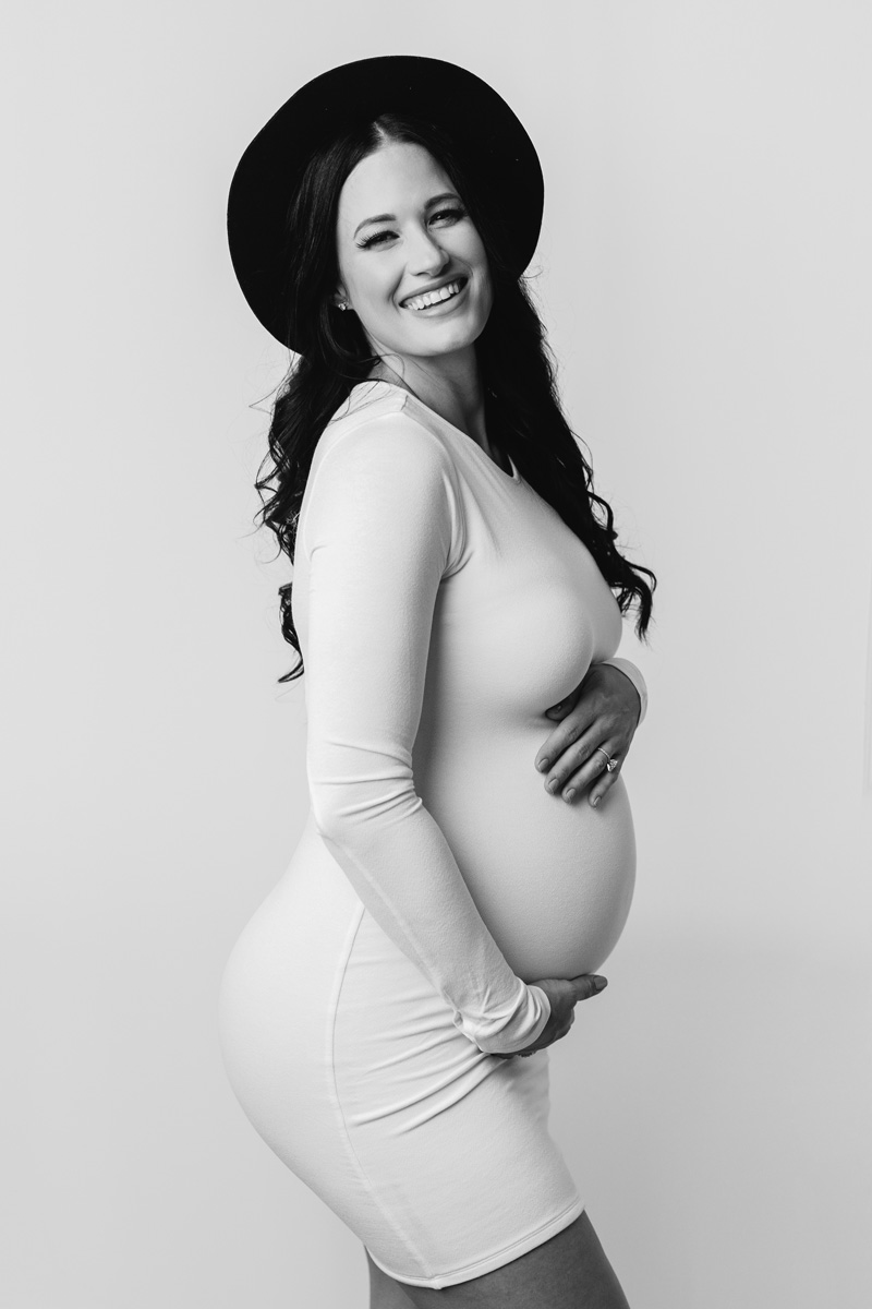 Boise modern maternity — joyful black-and-white portrait in a fitted dress and wide-brim hat