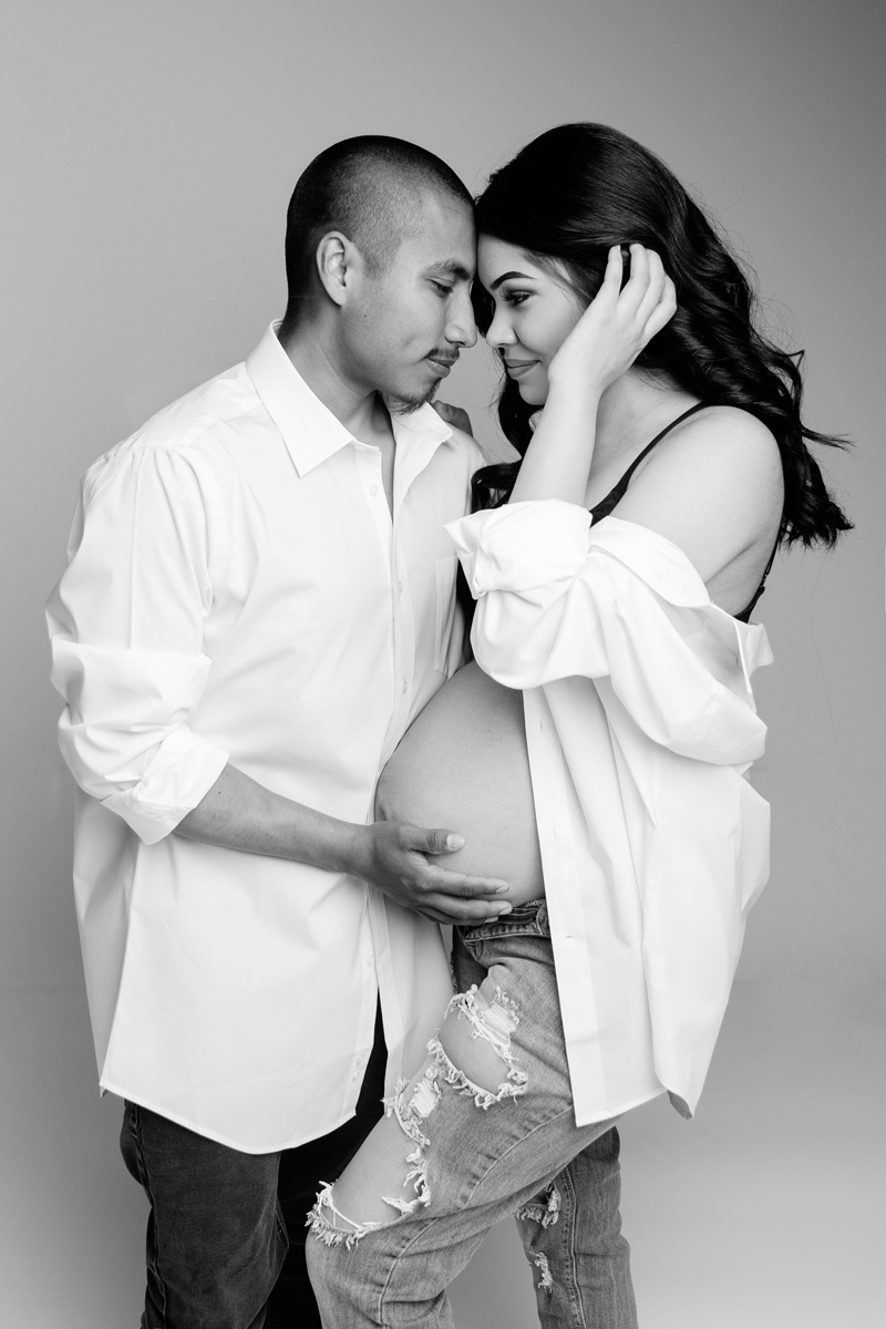 Boise modern maternity — black-and-white couples portrait, foreheads together with hands cradling the belly